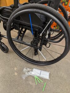 manual chair wheel with small reflector tubes that pop on over each spoke